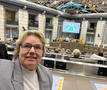 Veerle neemt een selfie in het parlement met het resultaat van de stemming op de achtergrond